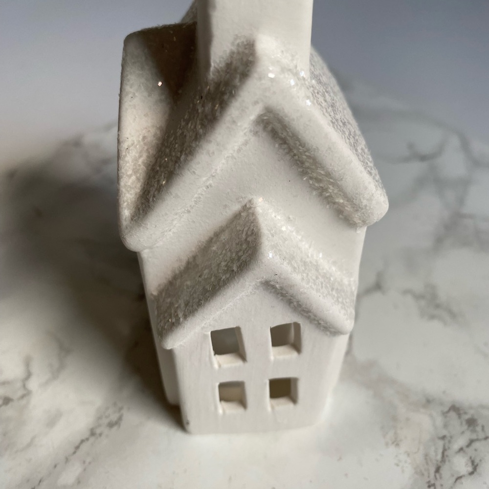 Ceramic house with white glitter. Gives the illusion of snow on the roof top .